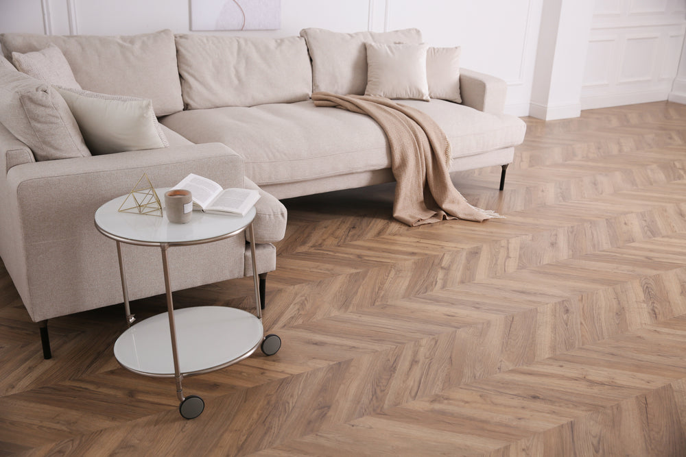LVT flooring in a living room with a beige L shaped sofa and side table