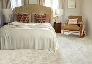 Neatly made bed with decorative pillows in a bedroom setting.